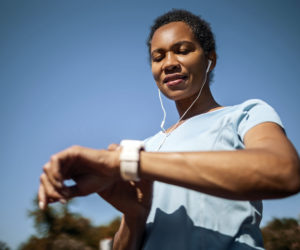 mulher atleta olhando para o smartwatch preso ao pulso