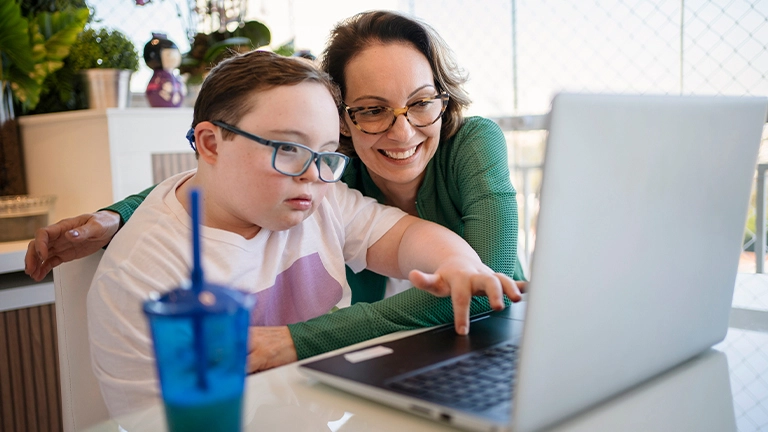 Menino com síndrome de down busca sobre a história da internet com a mãe